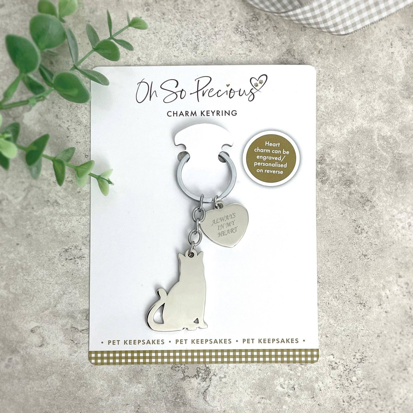 keyring with a cat and heart on it attached to cardboard packaging on a hard surface