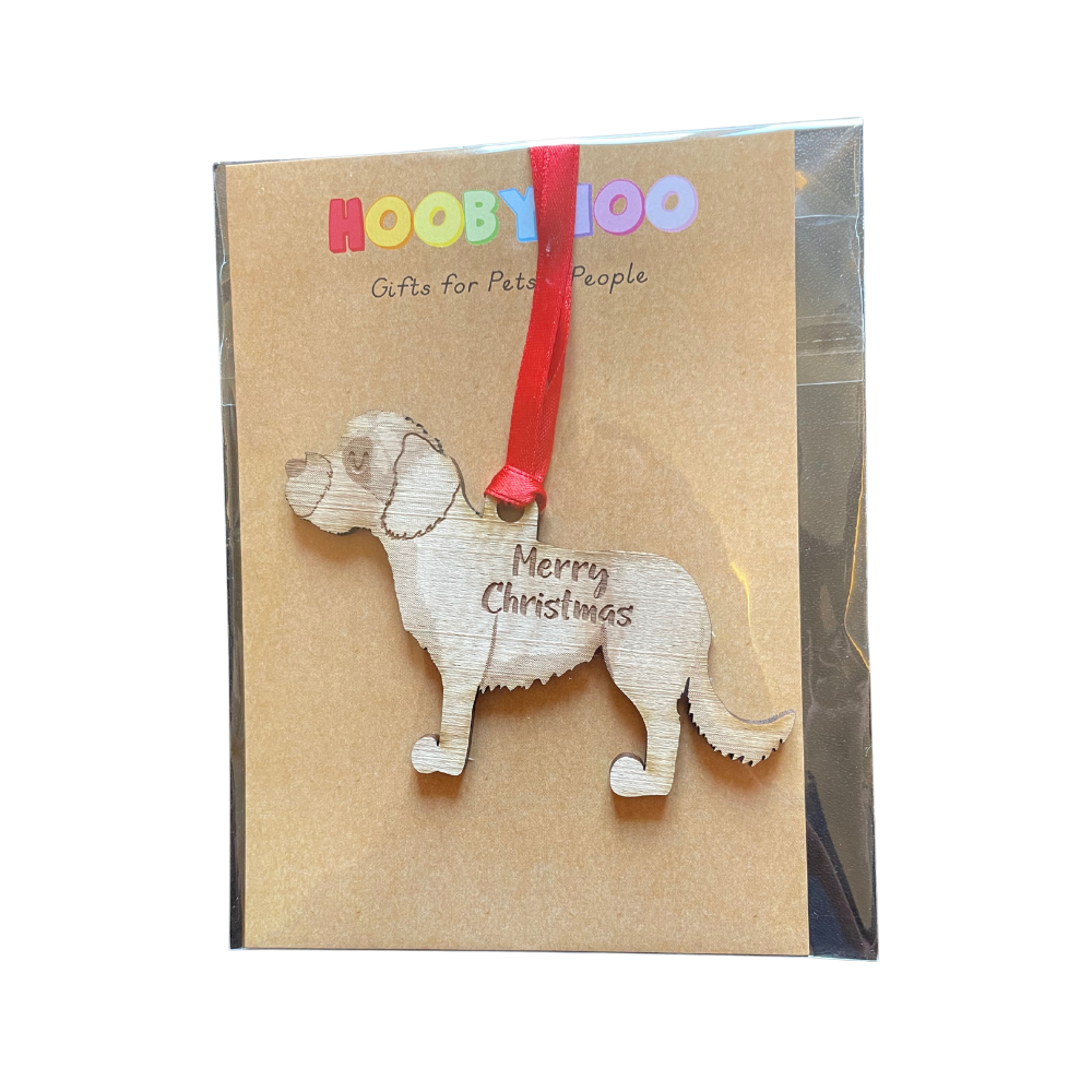 Dog-shaped Christmas ornament on a card with a red ribbon.