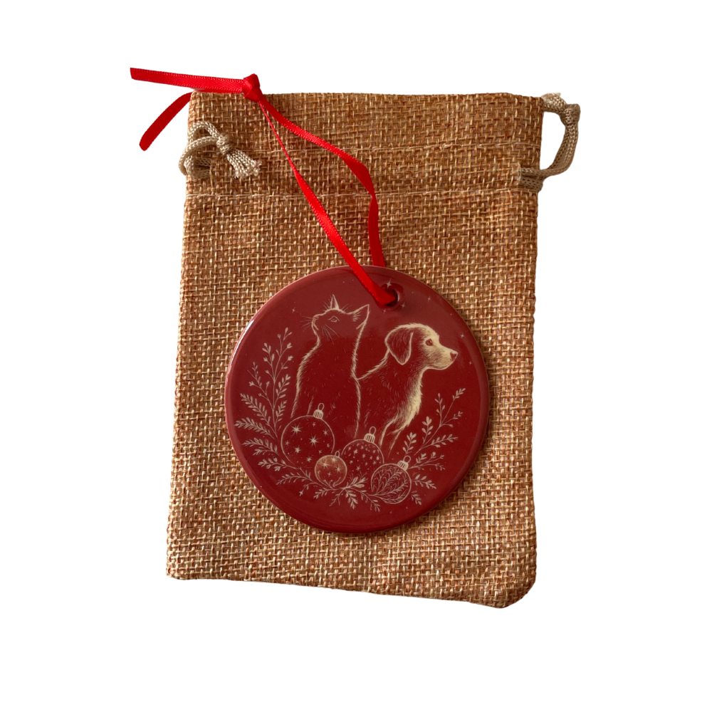 Decorative red ornament with a dog and cat design on a hessian bag with a red ribbon.