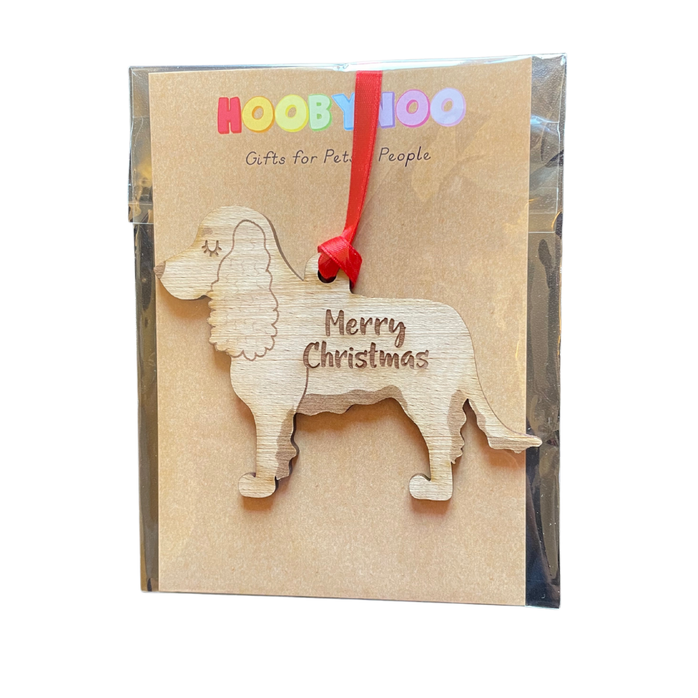 Wooden dog-shaped ornament with 'Merry Christmas' text on a branded packaging box.