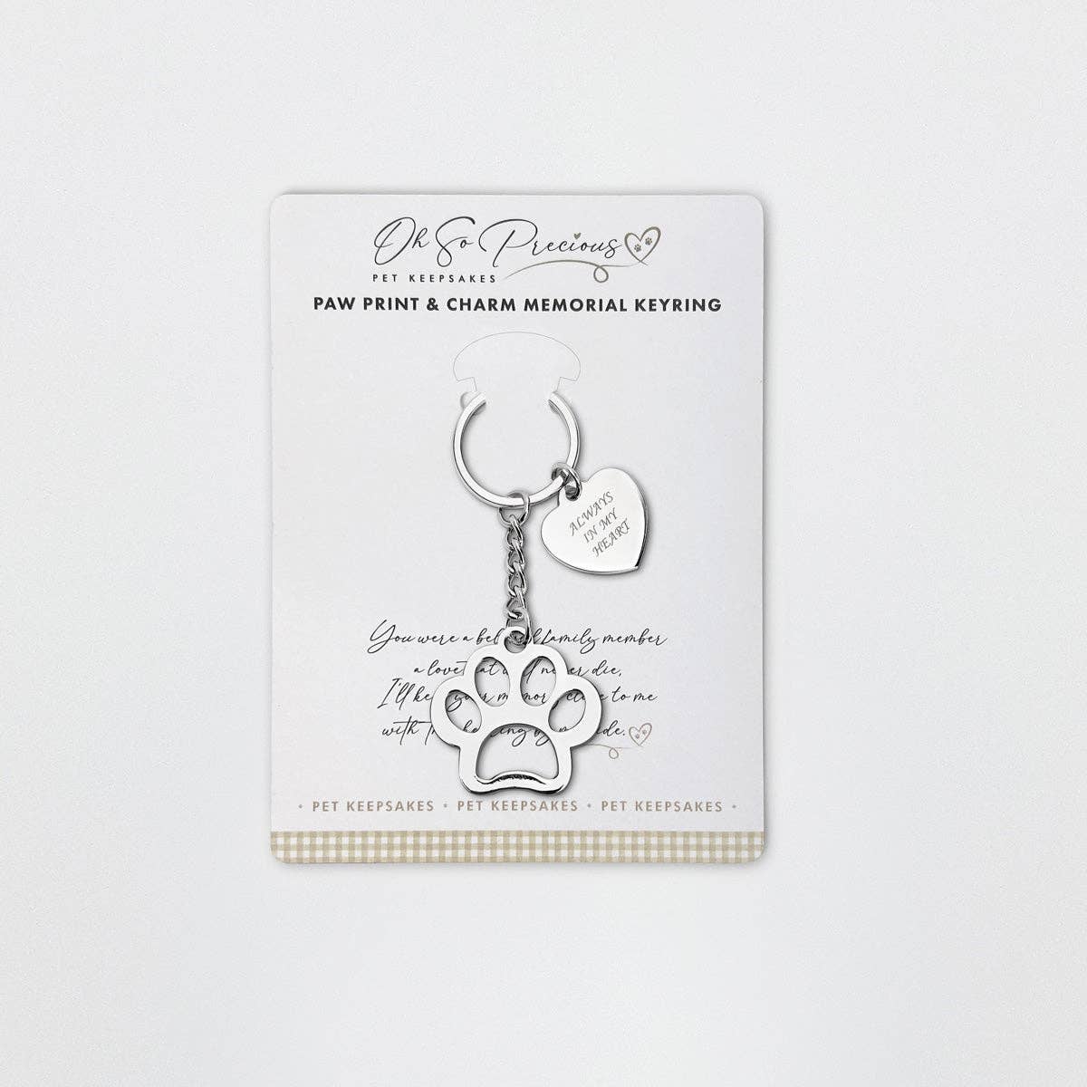 A stainless steel keyring with a cut out paw design and an engraved heart charm attached, featuring the inscription 'Always in my heart'. The product is presented on a card with a paw print and additional comforting text.