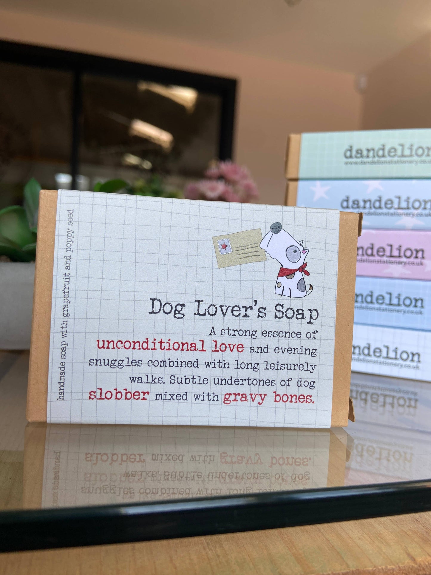 Soap box describing 'Dog Lover's Soap' with a dandelion product in the background.