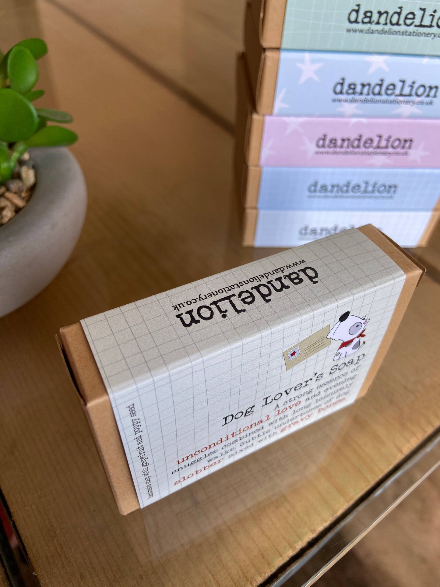 Box of 'Dog Lover's Soap' by Dandelion on a wooden surface with more boxes in the background.