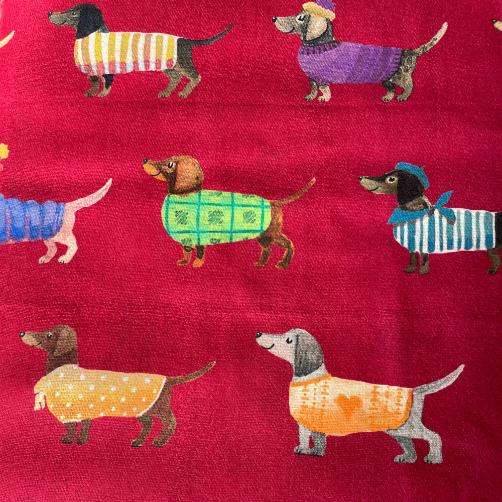 a red background with images of sausage dogs wearing different coloured coats.