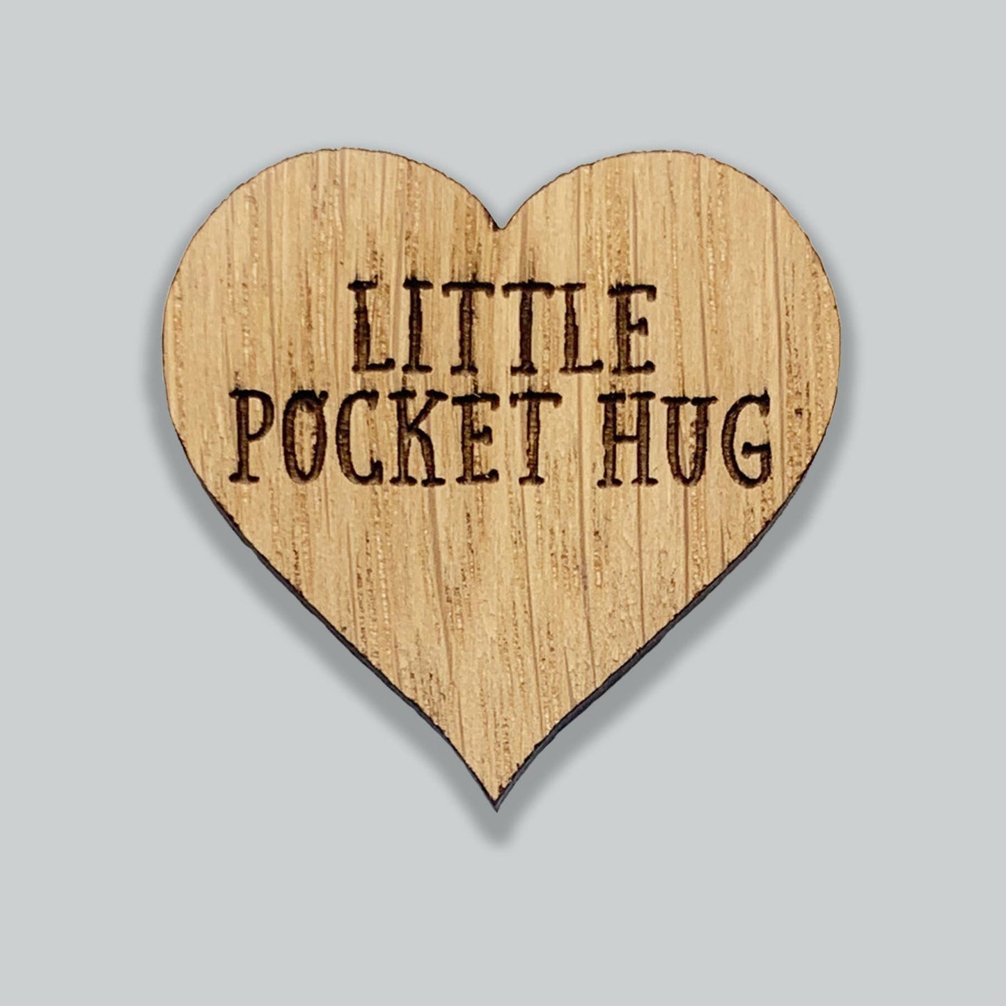 Heart-shaped wooden sign with 'Little Pocket Hug' text on a gray background