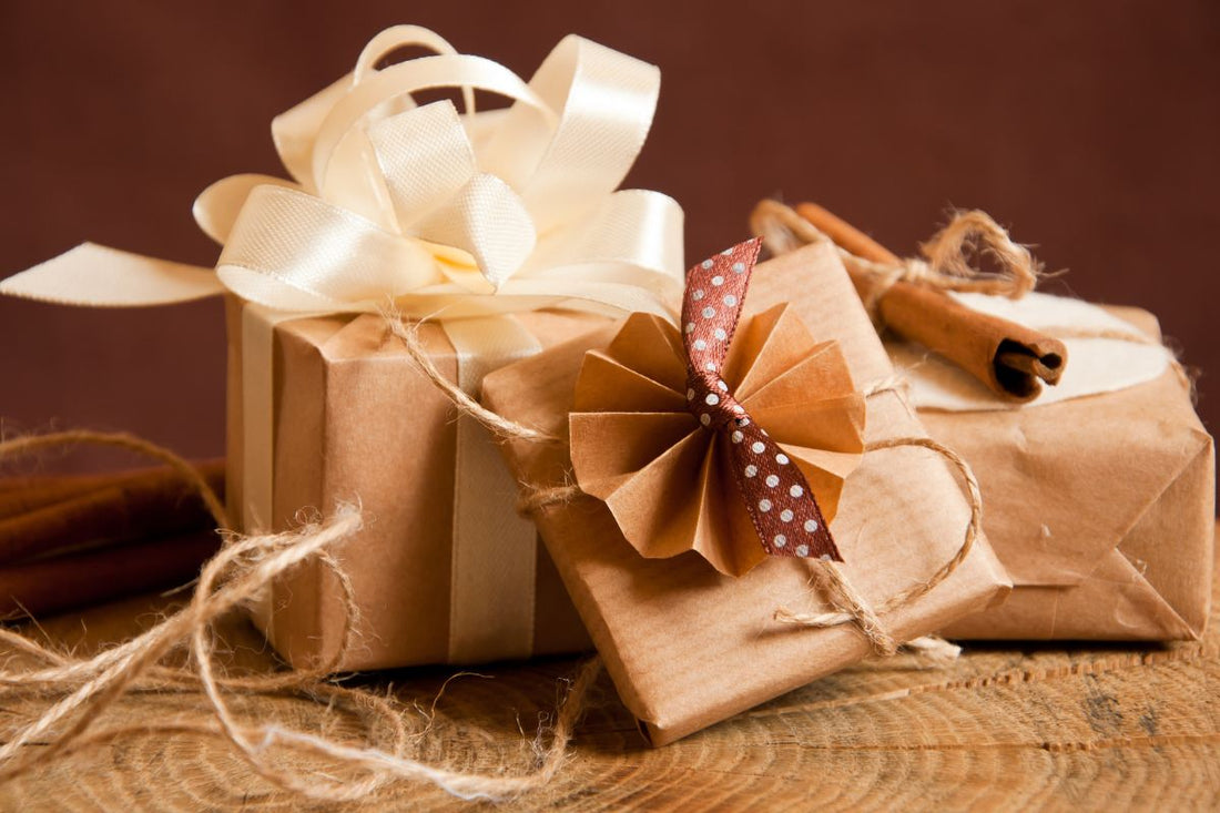 3 presents wrapped in brown paper with cream and brown bows. 