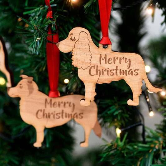 Wooden dog-shaped ornaments with 'Merry Christmas' text on a decorated tree.
