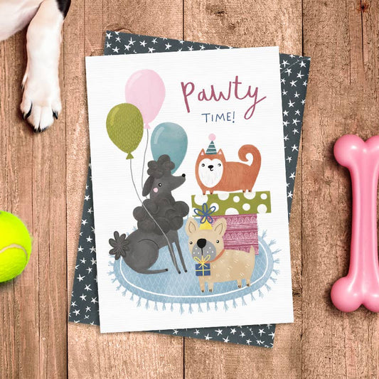 Card with cartoon animals and 'Pawty Time!' text on a wooden surface with dog toys.