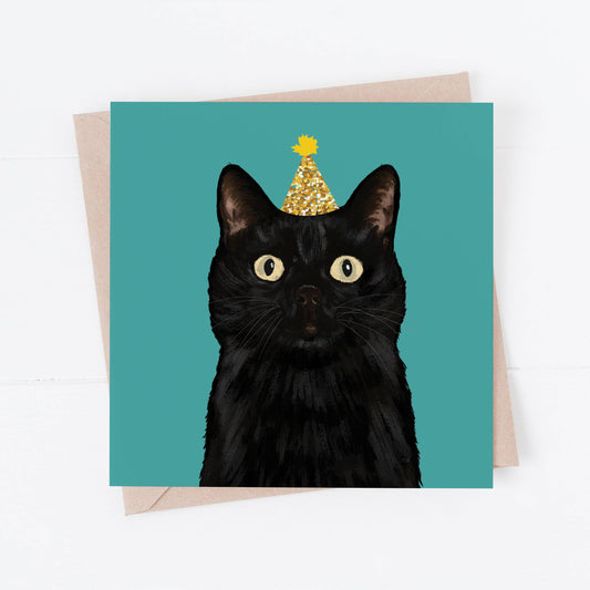 Greeting card with a black cat wearing a gold crown on a teal background
