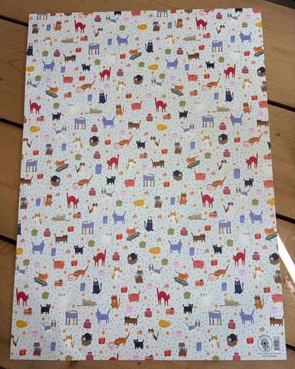 Sheet of paper with colourful cat pattern on a wooden surface