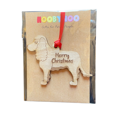 Wooden dog-shaped ornament with 'Merry Christmas' text on a branded packaging box.