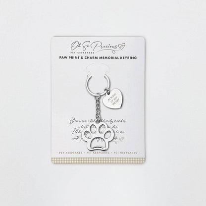 A stainless steel keyring with a cut out paw design and an engraved heart charm attached, featuring the inscription 'Always in my heart'. The product is presented on a card with a paw print and additional comforting text.