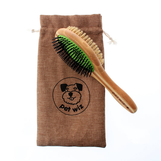 Pet grooming brush with green bristles on a brown drawstring bag labeled 'pet wiz' on a white background.