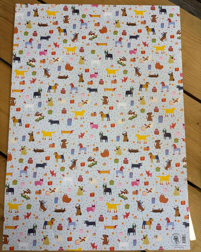 Sheet of paper with colourful dog illustrations on a wooden surface