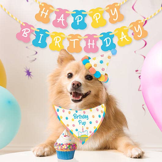 A dog wearing a birthday hat and bandana with 'Happy Birthday' text in the background, celebrating its special day.