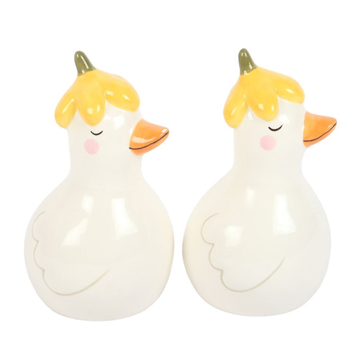 Two ceramic duck-shaped salt and pepper shakers with yellow hair on a white background