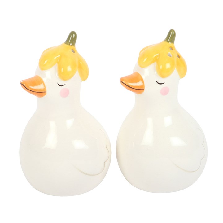 Two ceramic ducks with yellow hair and orange beaks on a white background