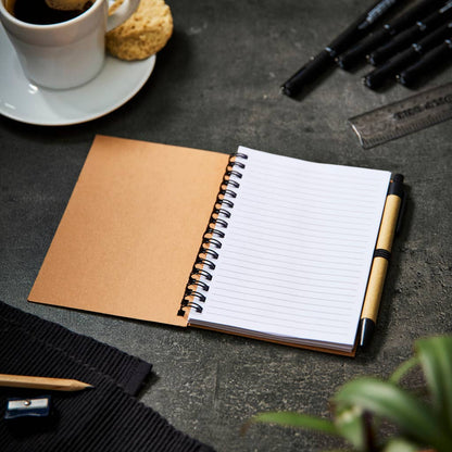 An open notepad with lined white paper and pen next to it. 