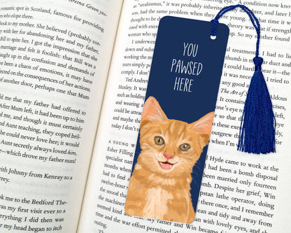 Bookmark with a cat illustration and 'You Pawsed Here' text on an open book