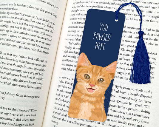 Bookmark with a cat illustration and 'You Pawsed Here' text on an open book