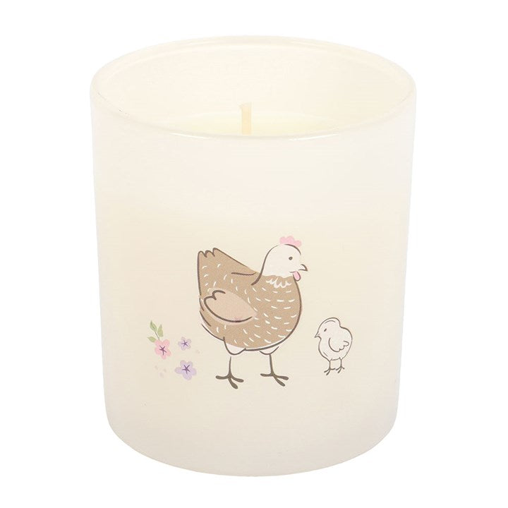 Candle with a design of a mother hen and chick on a white background