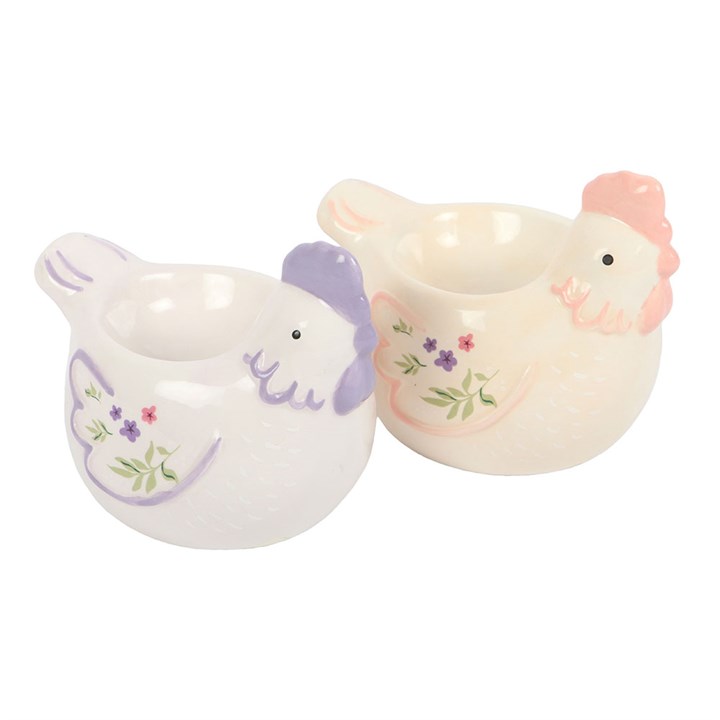 Two ceramic chicken-shaped egg cups with floral designs on a white background