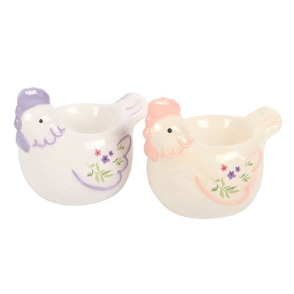 Two ceramic hen egg cups with floral designs on a white background