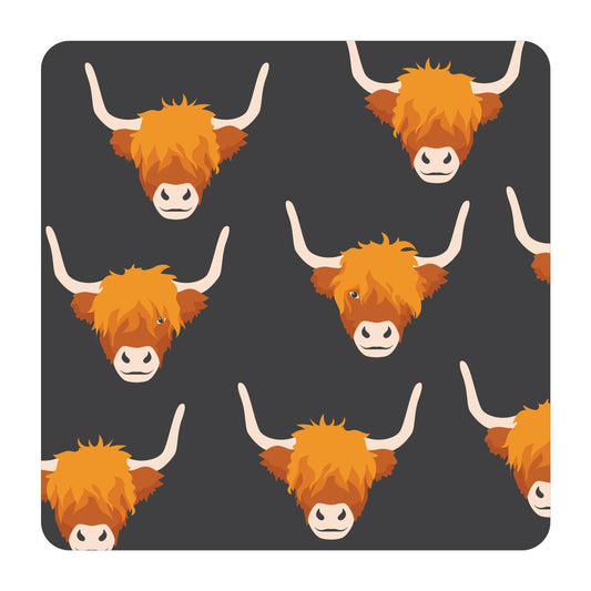 a coaster with highland cow design on a dark background 