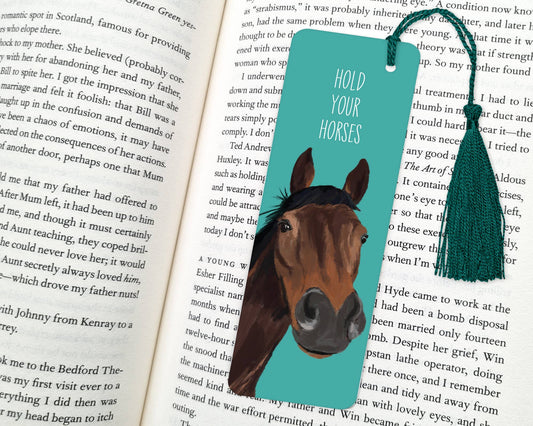 Bookmark with horse illustration and text 'Hold Your Horses' on an open book