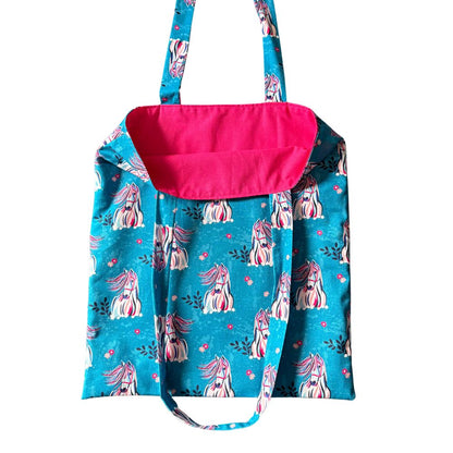Blue bag with pink interior and horse pattern on a white background