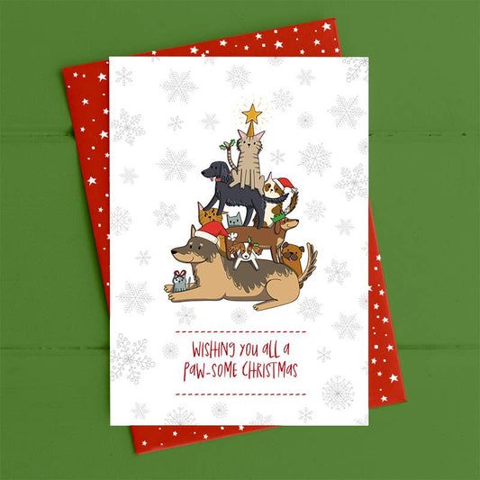 Christmas card with cartoon dogs and cats forming a Christmas tree on a green background