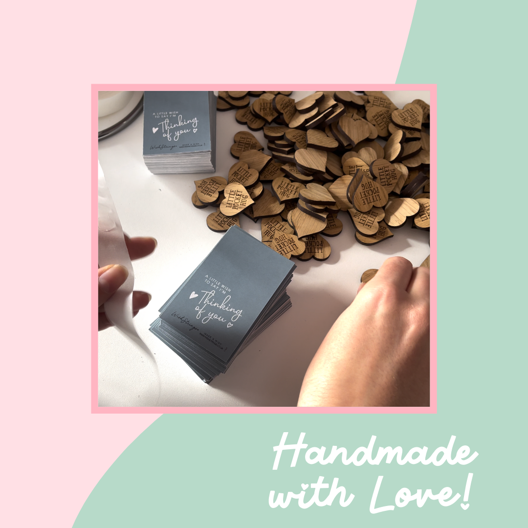 Heart-shaped wooden tokens and cards with 'Thinking of you' text on a pink and green background.