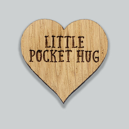 Heart-shaped wooden sign with 'Little Pocket Hug' text on a gray background