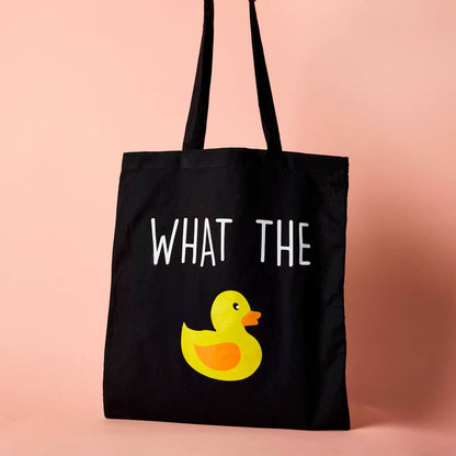 Black cotton tote bag with a yellow duck illustration and the phrase 'WHAT THE' printed in white.